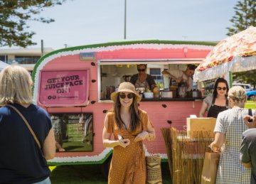 Image of lady standing in front of a caravan at the markets